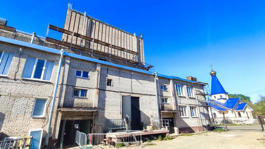 Кирпичное здание в ремонте рядом с православным храмом