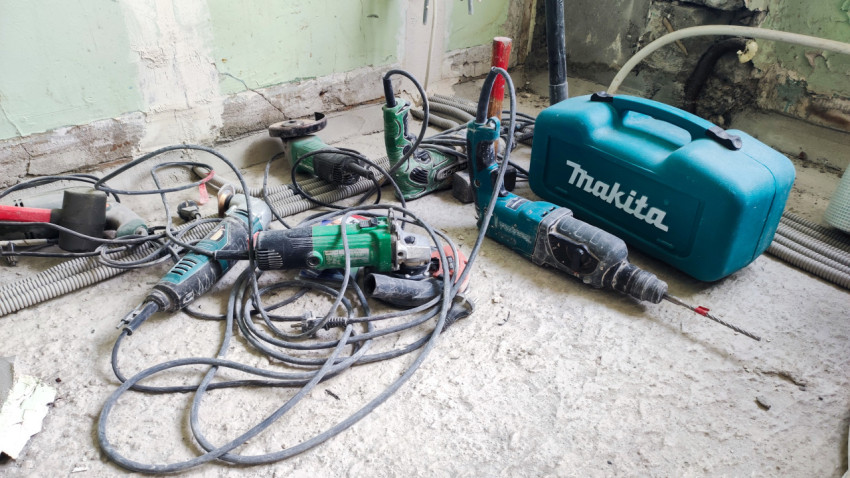 Электроинструменты и чемодан Makita на полу помещения в ремонте