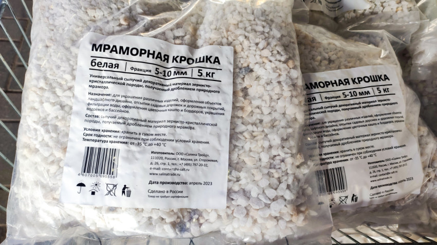 Пакеты белой мраморной крошки фракции 5–10 мм на торговой витрине