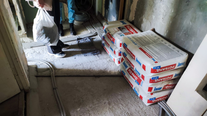 Строительные смеси и электропроводка в коридоре на этапе ремонта