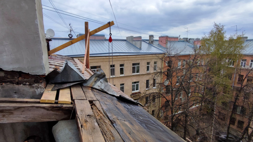 Покрытие кровли в процессе демонтажа и вид на соседние дома