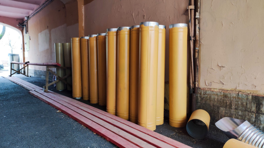 Строительные материалы и трубы под аркой дворового прохода