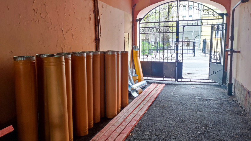 Строительные трубы и доски под аркой двора в Санкт-Петербурге