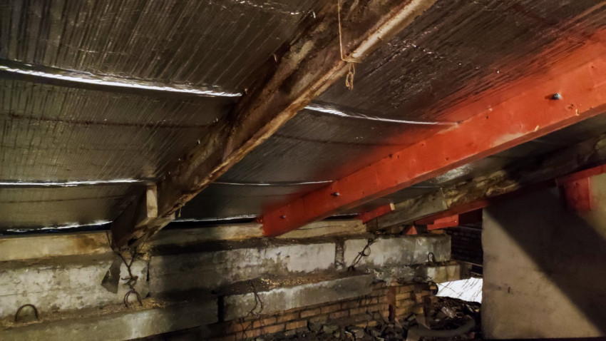 Опорные балки кровли и кирпичная кладка чердачного уровня