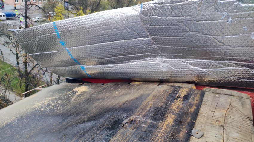 Рулон утеплителя, размещенный на кровле во время ремонтных работ