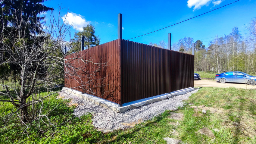 Металлическое ограждение на участке в весеннем ландшафте