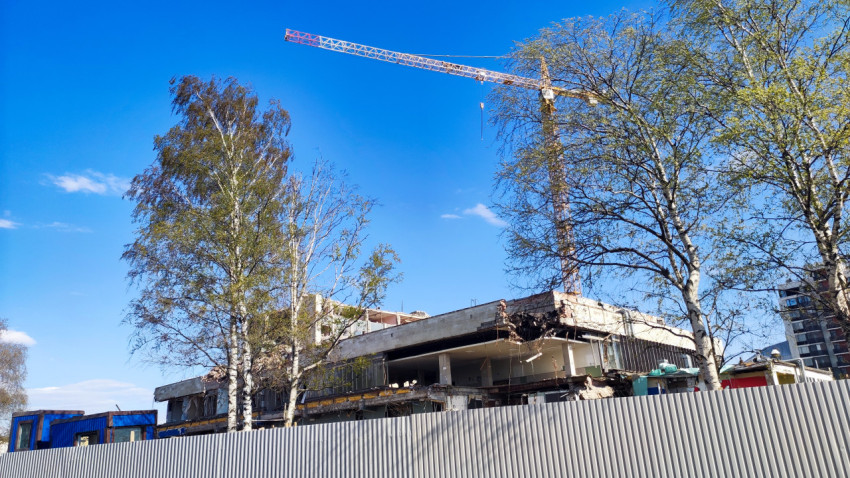 Демонтируемое здание и строительный кран за ограждением