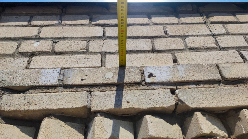Измерение вертикального смещения кирпичного ряда на фасаде