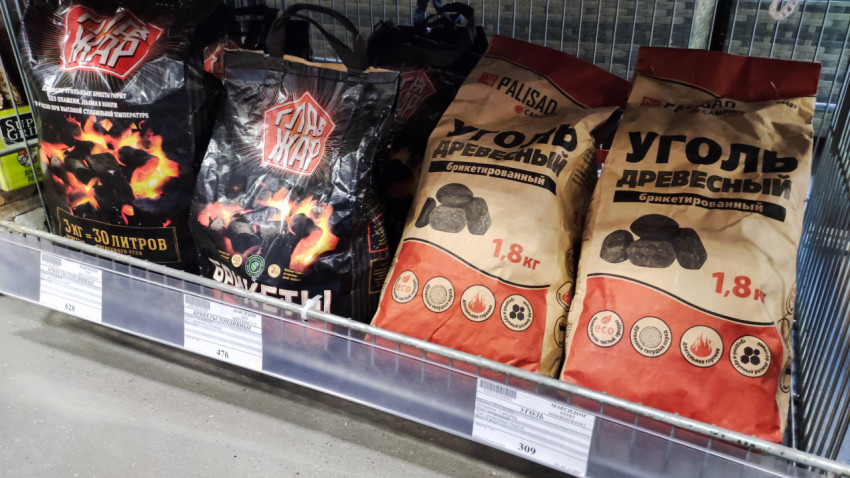 Уголь древесный и брикеты разных брендов на нижней полке