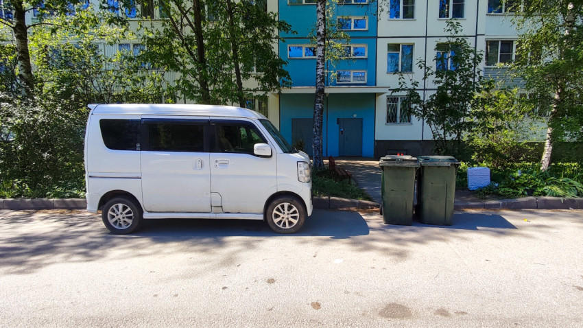 Suzuki Every Wagon рядом с контейнерами на фоне жилого дома