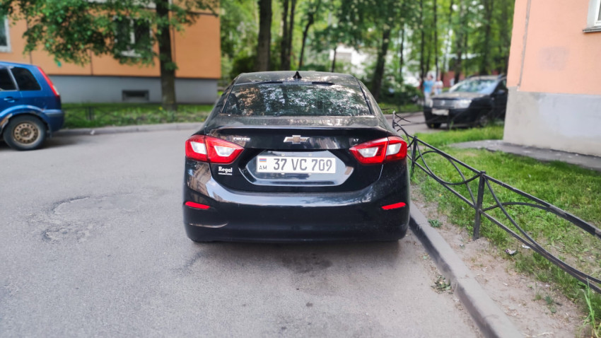 Автомобиль Chevrolet возле жилого дома на дворовой парковке