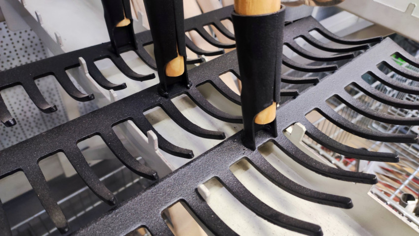 Металлические грабли с деревянными черенками на торговом стеллаже