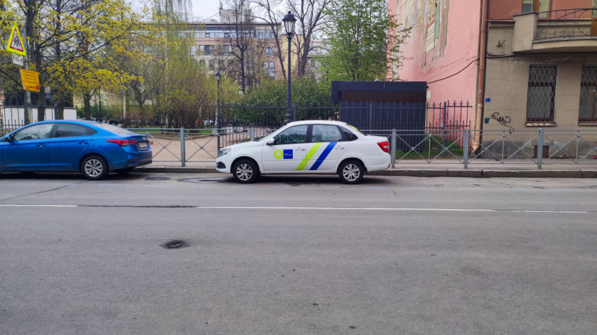 Автомобиль парковочного оператора на улице рядом с жилыми домами