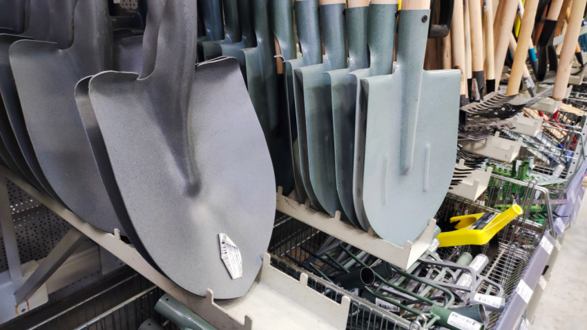 Стальные лопаты с деревянными черенками на витрине магазина