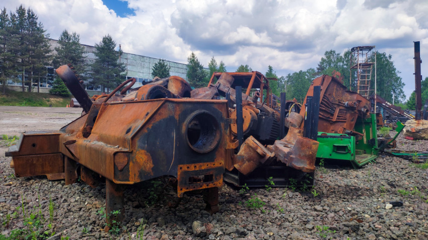Крупные металлические корпуса разобранной техники на щебёночной площадке