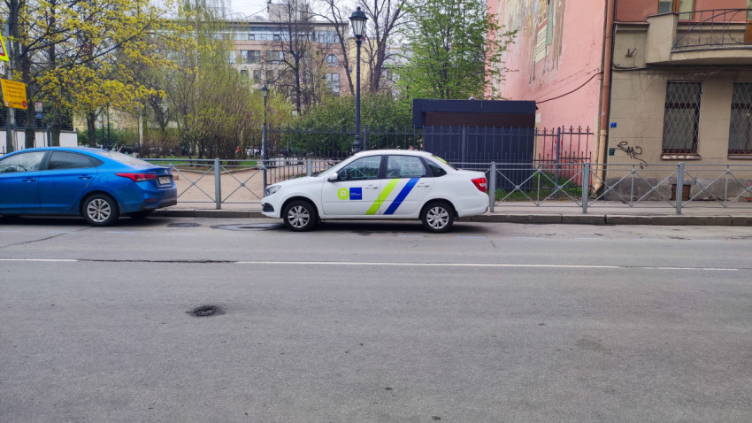 Служебный автомобиль парковочного оператора на городской улице