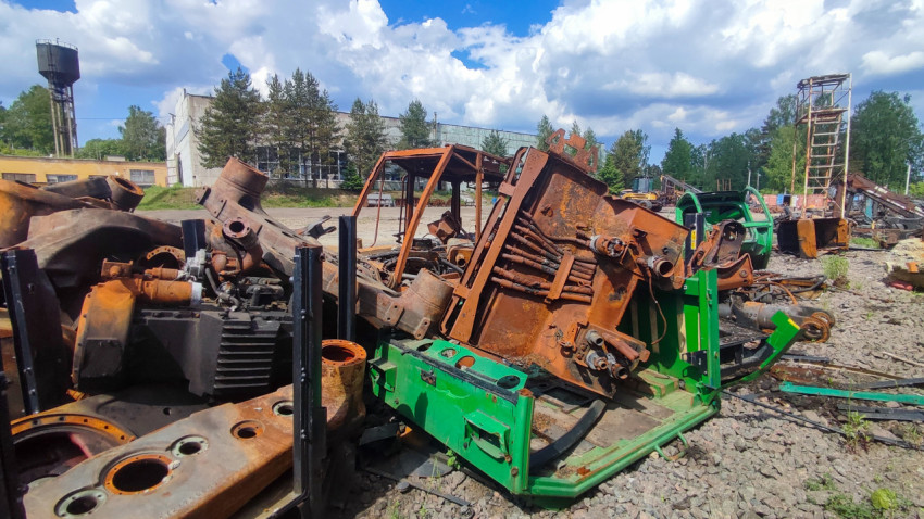 Объёмная куча металлических фрагментов разобранной техники на промышленной площадке