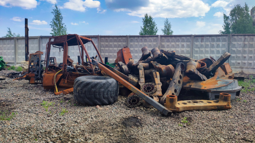 Разобранная техника и металлические детали на промышленной площадке
