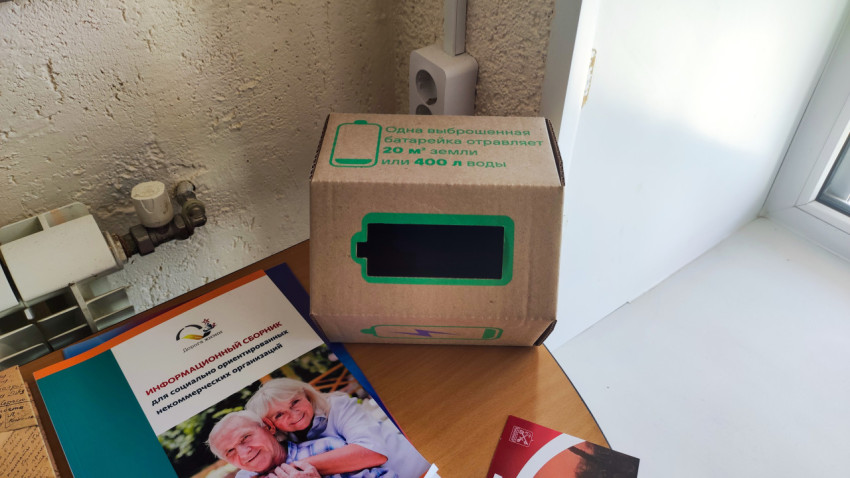 Коробка для сбора использованных батареек на столе в помещении