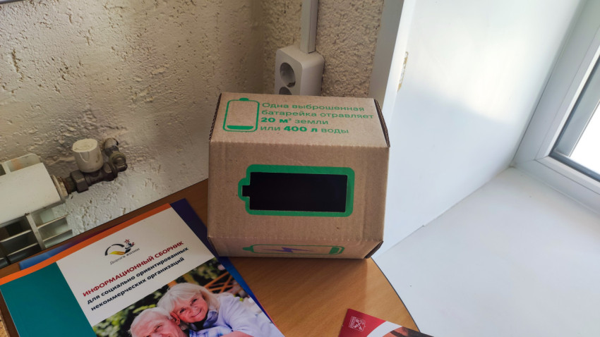 Коробка для сбора батареек на столе у окна