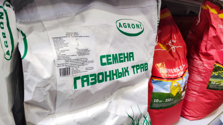 Мешки с семенами газонных трав на полке магазина