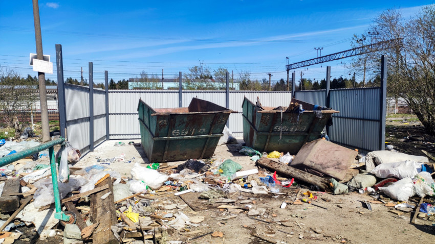 Металлические контейнеры для мусора на фоне железнодорожной линии