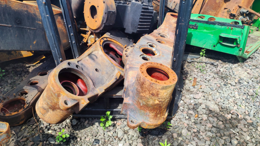 Ржавые металлические корпуса и узлы тяжёлой техники на фоне промышленного двора