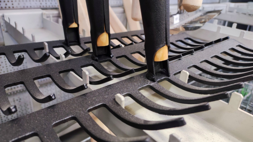 Крупный план черенков и металлических грабель на торговой витрине