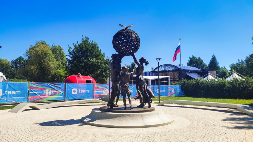 Скульптурная композиция «Семья — залог мира» с земным шаром и голубями на фоне фестивальных конструкций в Парке 300-летия