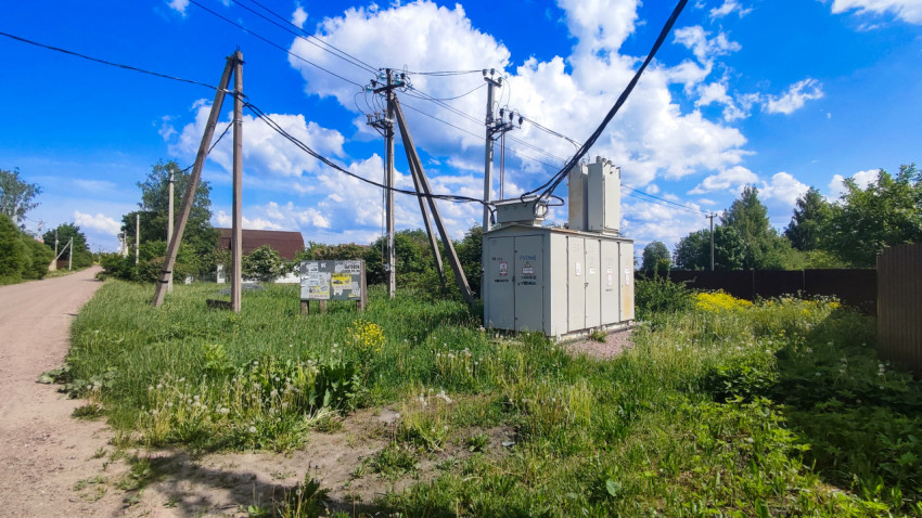 Распределительный электрощит и опоры ЛЭП у сельской дороги