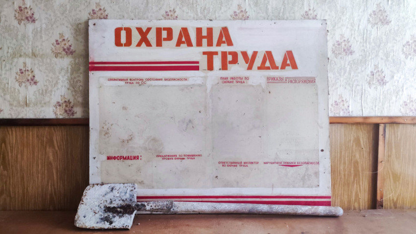 Крупный план стенда «Охрана труда» с пустыми карманами и лопатой