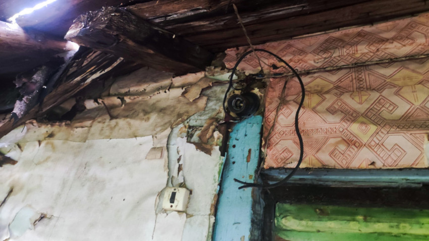 Старая электропроводка и поврежденные стены в заброшенном доме