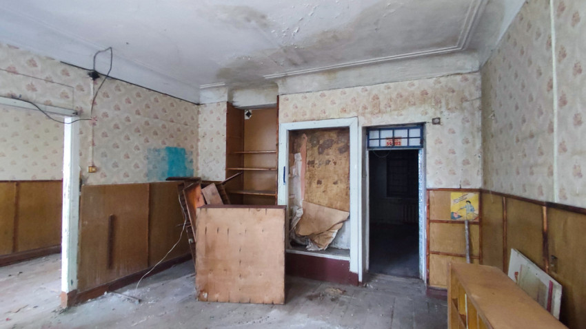 Заброшенный интерьер с дверным проёмом и стеклоблоками в фрамуге