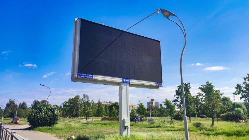 Пустой цифровой билборд на опоре в зелёной зоне