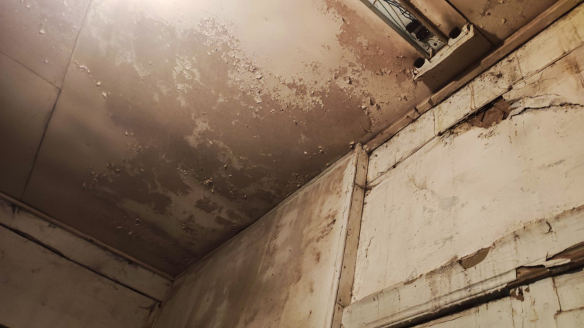 Угол потолка с отслаивающейся краской и кабель-каналом в старом помещении