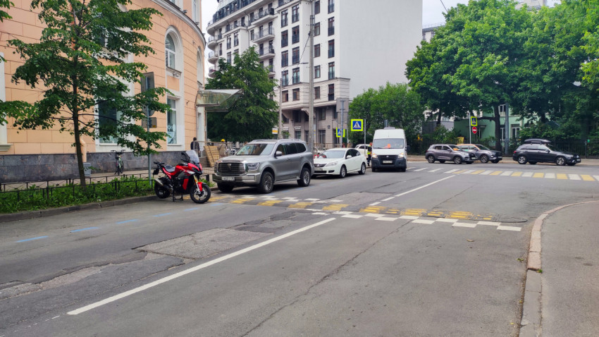 Городская улица с пешеходным переходом, автомобилями и припаркованным мотоциклом