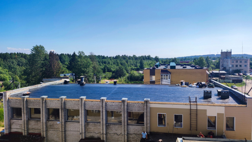 Панорамный вид здания с обновляемой плоской кровлей, покрытой синей мембраной