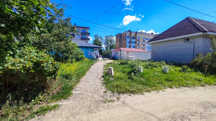 Пешеходная тропа к дворовым постройкам и многоэтажным домам под линиями проводов