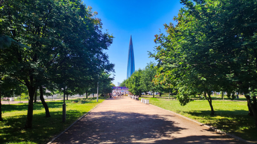 Аллея в парке ведёт к небоскрёбу Лахта Центр на горизонте в Санкт-Петербурге