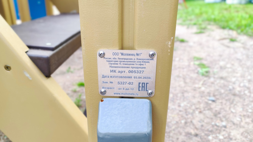 Шильдик производителя на стойке игрового комплекса с данными изделия