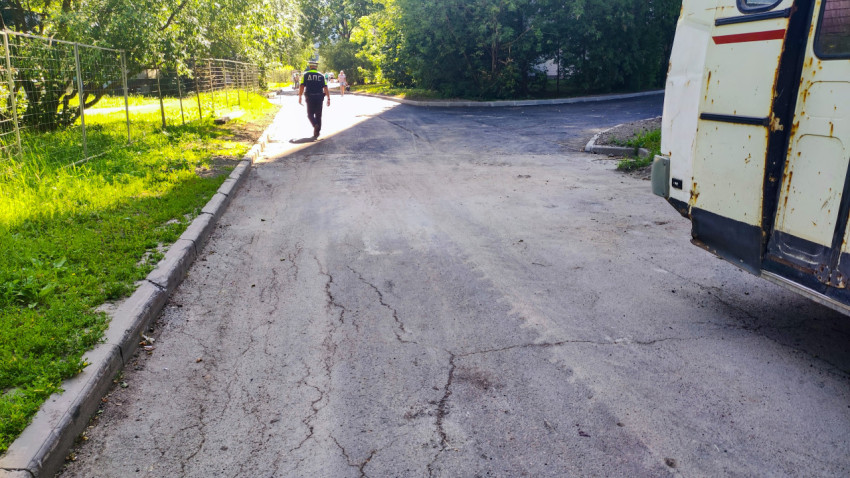 Сотрудник ДПС идёт по дороге рядом с новым асфальтом и старым автобусом на обочине