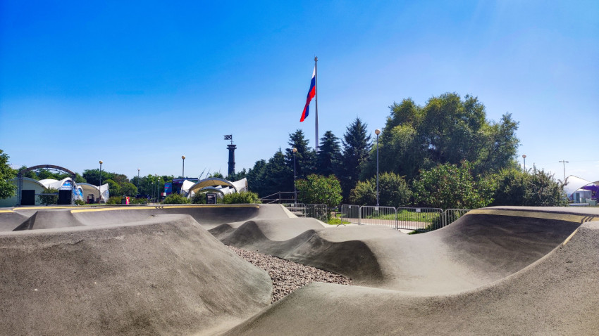 Памп-трек с поворотами и «волнами» на фоне деревьев и мачты с флагом