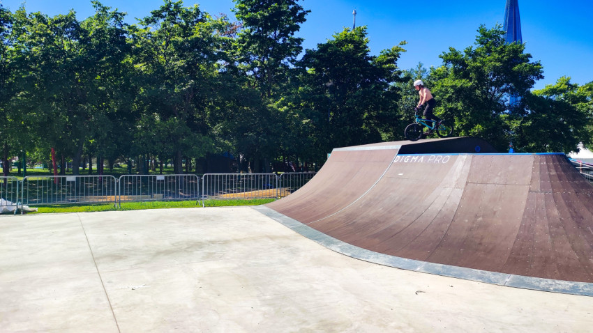 BMX-райдер на рампе Digma Pro на открытой площадке среди деревьев