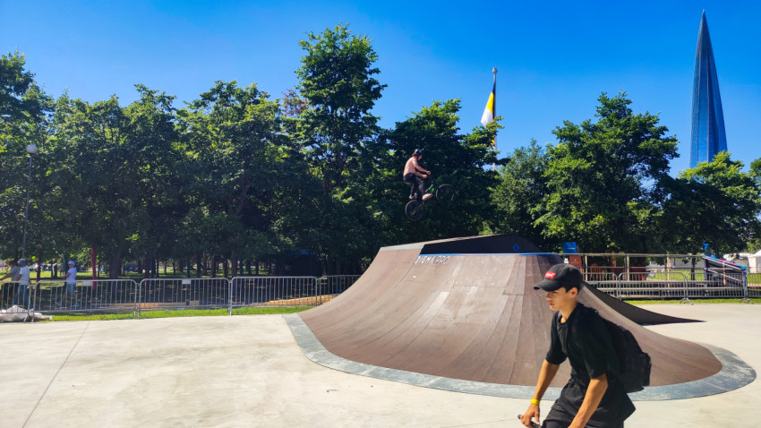 Прыжок BMX над рампой на фоне парка и небоскрёба «Лахта Центр»