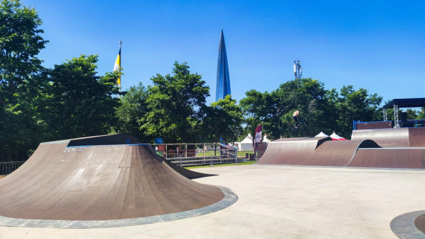 Скейтпарк с несколькими рампами и BMX-райдером на дальнем вылете