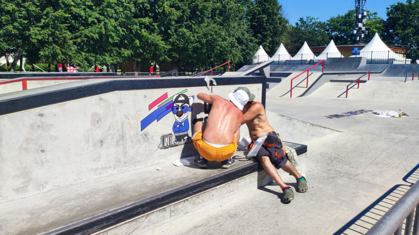 Два художника расписывают бетонный боул скейтпарка перед соревнованиями на площадке VK Fest