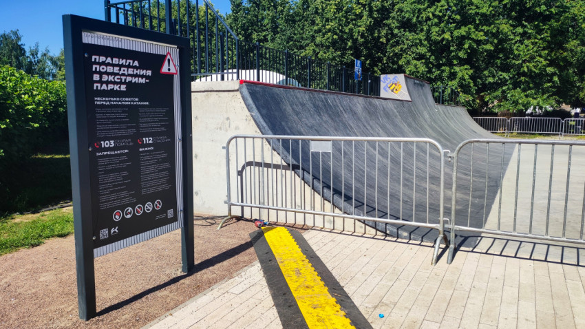 Информационный щит с правилами поведения в экстрим-парке рядом с рампой и ограждениями