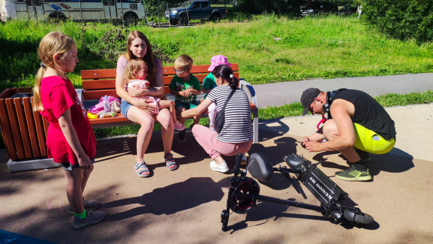 Взрослые и дети собрались у лавки рядом с упавшим электросамокатом на площадке