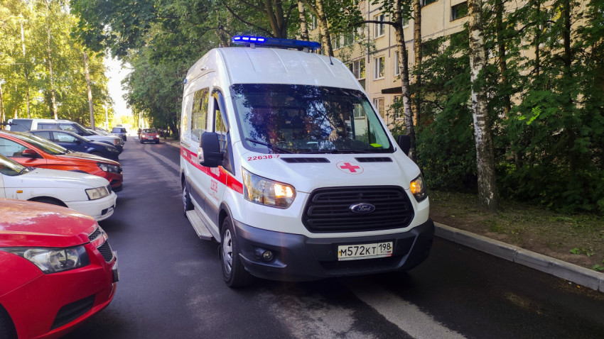 Автомобиль скорой помощи с включёнными маячками остановился у бордюра во дворе жилого дома