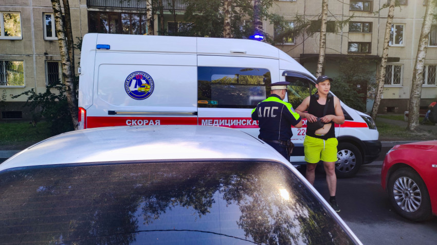 Сотрудник ДПС разговаривает с мужчиной рядом с машиной скорой медицинской помощи